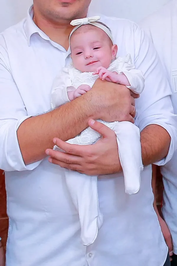 אבא מחזיק את התינוקת שלו בבריתה. צולם על ידי צלם לבריתה של מגנטסטאר צילום אירועים