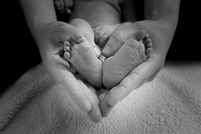 רגלי תינוק בתוף כף יש של אמא