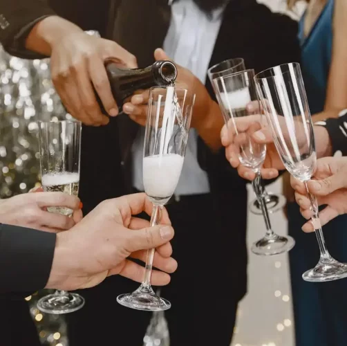 אנשים מוזגים שמפנייה לכוסות לקראת החגיגה. צולם בעת צילום סטילס לאירועים. תחת קטגוריית אירועים של מגנטסטאר צילום אירועים