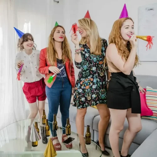 ארבע נשים חוגגות עם כובעי מסיבה ועוד אביזרי מסיבה. נלקח מצילום של צלם וידאו לאירוע קטן. תחת קטגוריית אירועים של מגנטסטאר צילום אירועים