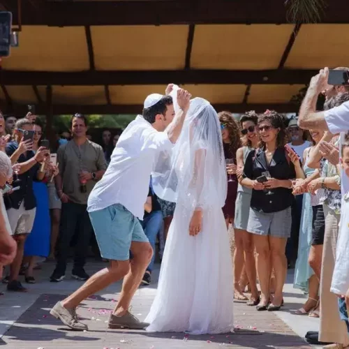 חתן מנשק את כלתו בחתונה שלהם ביום שישי.צולם על ידי צלם חתונות של מגנטסטאר צילום אירועים