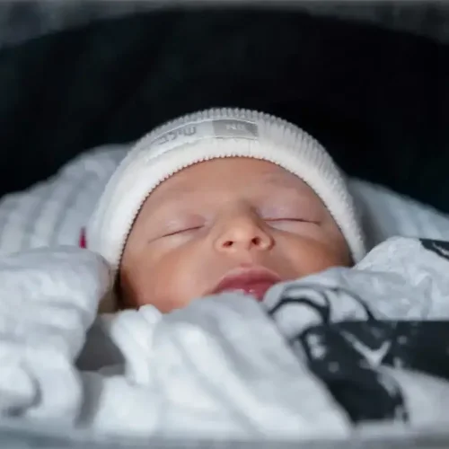 תינוק ישן עם כובע בעגלה לפני הברית. צולם על ידי צלם לברית של מגנטסטאר צילום אירועים